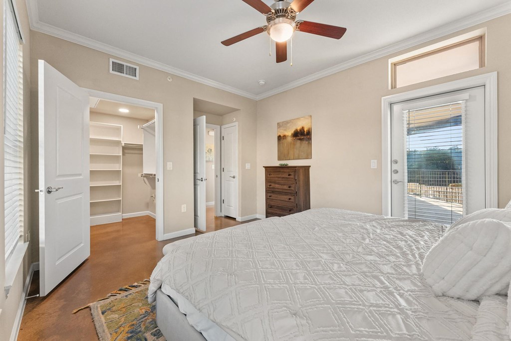 A bedroom with a large bed and a ceiling fan. at Bridge at Heritage Woods, Texas, 78753