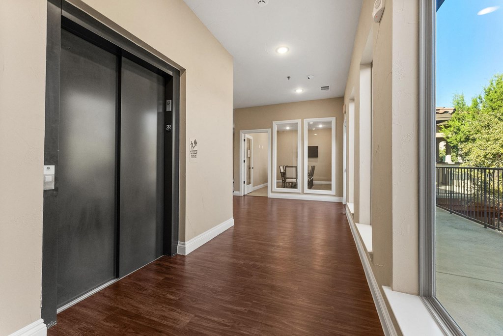 A hallway with a black door on the left and a glass door on the right. at Bridge at Heritage Woods, Austin, TX