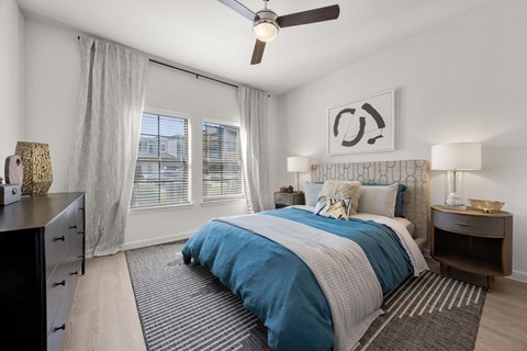 A bedroom with a bed, nightstands, and a ceiling fan. at Bridge at Tech Crossing, Austin