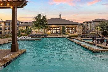 A large outdoor swimming pool with a wooden pergola over it. at The Royce at 8100, Austin, Texas