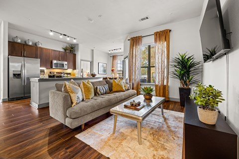 A modern living room with a grey couch and a wooden floor.