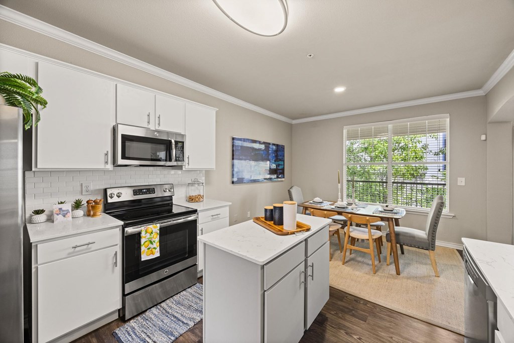 A kitchen with white cabinets and a black stove top oven.
