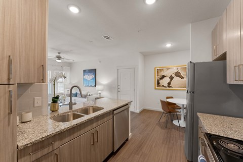 A modern kitchen with wooden cabinets and a granite countertop.