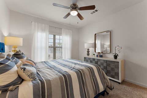 A bedroom with a bed, a dresser, and a mirror.