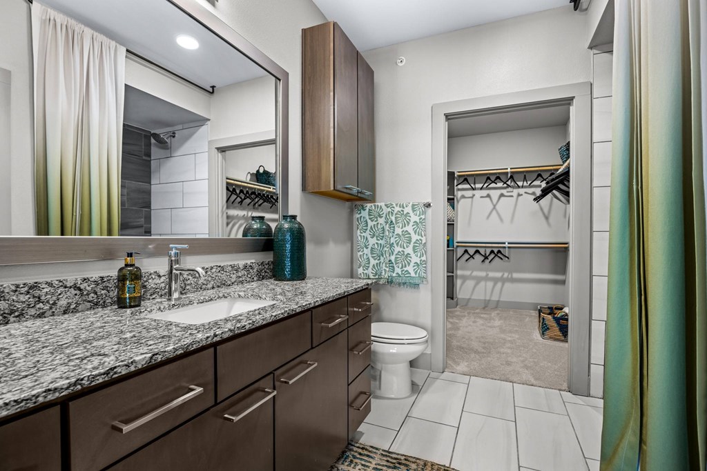 A bathroom with a sink, mirror, and toilet. at Bridge at Henley, Austin, TX, 78741