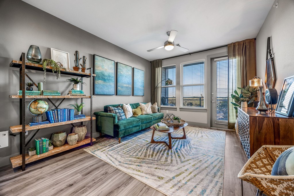 A living room with a green couch and a wooden coffee table. at Bridge at Henley, Austin, TX, 78741