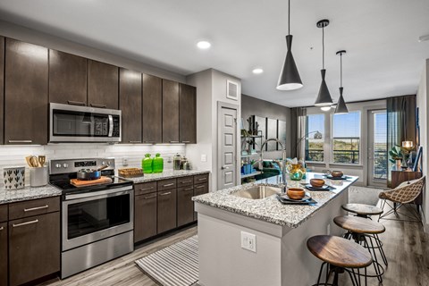 A modern kitchen with dark wood cabinets and stainless steel appliances.