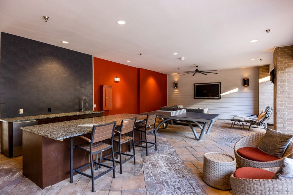 A modern kitchen with a bar area and seating. at Bridge at Henley, Austin, TX