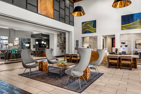 A modern living room with grey chairs and a wooden coffee table.