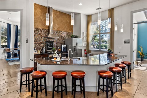 A kitchen with a bar area featuring a counter and stools.