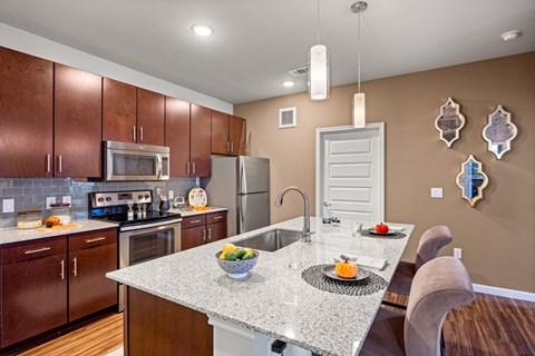 A kitchen with brown cabinets and a granite countertop.