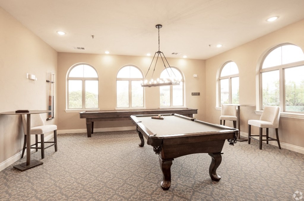 a game room with a pool table and a bar