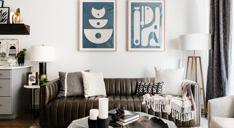 a living room with a couch and two paintings on the wall