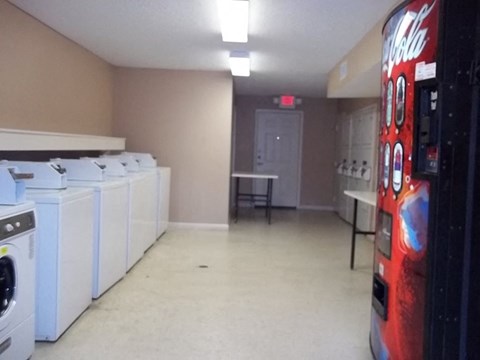 a washer and dryer room with coke machines