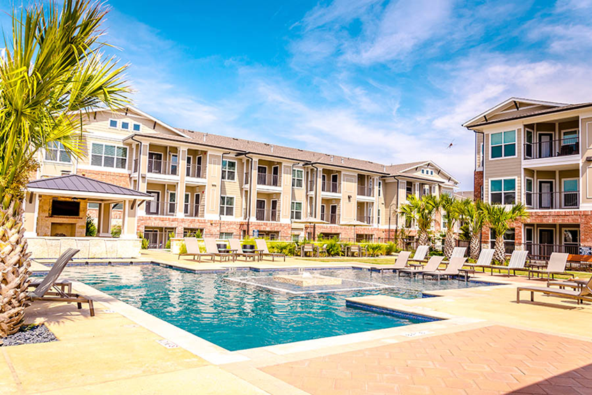 a large swimming pool in front of an apartment building