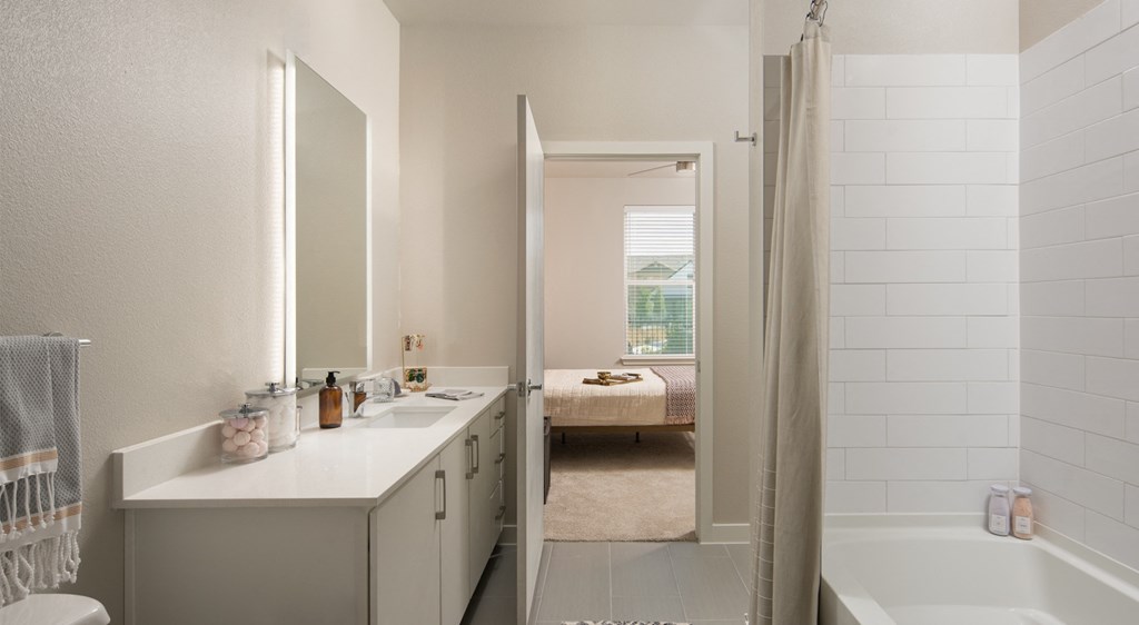 a bathroom with a tub and a sink and a mirror