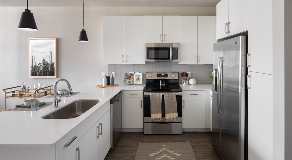 a white kitchen with stainless steel appliances and white cabinets