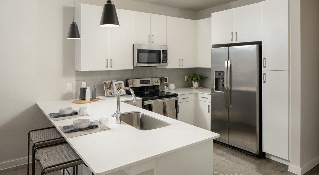 a kitchen with white counter tops and stainless steel appliances