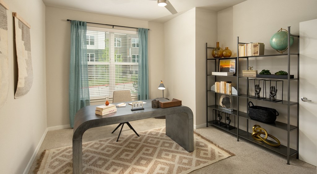 a home office with a large window and a large table