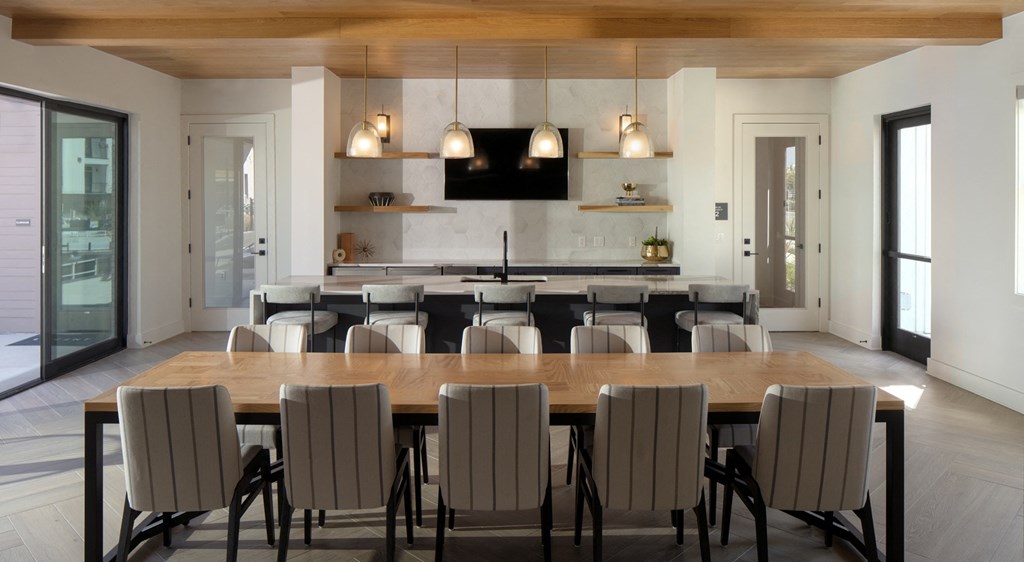 a dining room table with chairs in front of a kitchen
