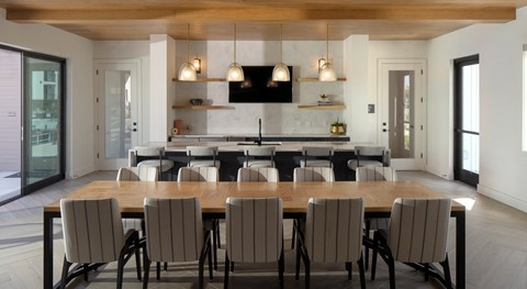 a dining room table with chairs in front of a kitchen
