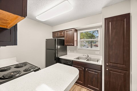 A kitchen with a black stove top oven and a black refrigerator.