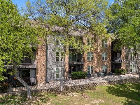 A large building with a balcony and a tree in front of it. at Montecito, Texas, 78741
