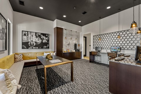 A modern living room with a yellow sofa and a black and white patterned rug.
