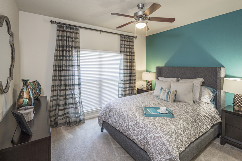 a bedroom with a large bed and a ceiling fan
