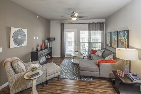 a living room with a couch and a chair and a ceiling fan