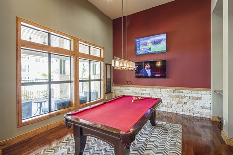 a pool table in a living room with a tv