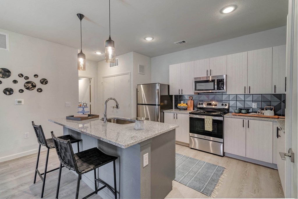 a kitchen with a marble counter top and stainless steel appliances