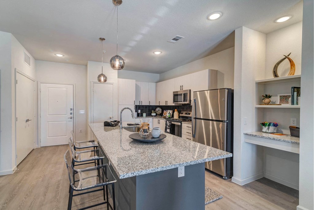 a kitchen with a island and a stainless steel refrigerator