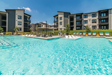 a large swimming pool with an apartment building in the background