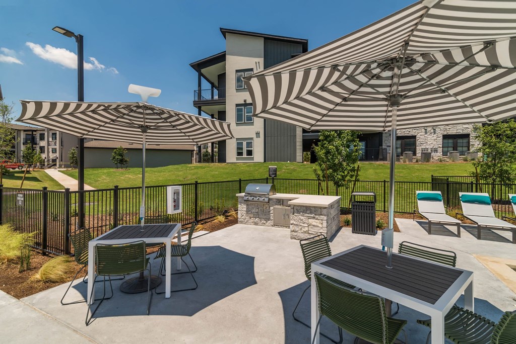 private patio with tables and umbrellas at the preserve at polk apartments
