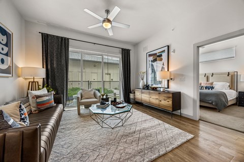 A modern living room with a brown leather couch and a glass coffee table.
