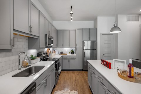 A modern kitchen with a white countertop and grey cabinets. at The Haywood Apartments, Austin, TX, 78748