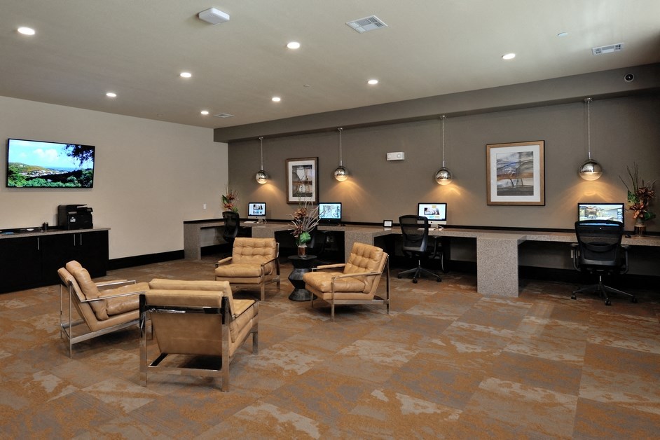 a large lobby with chairs and a desk with computers