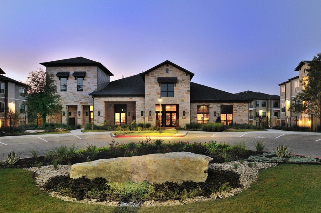 a large rock in front of a building at night