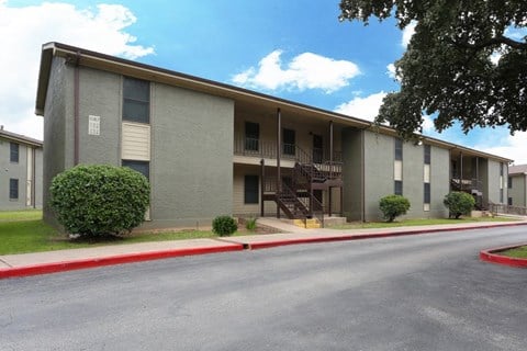 an apartment building with a red curb and a street