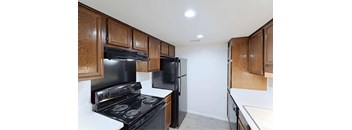 A kitchen with black appliances and wooden cabinets.