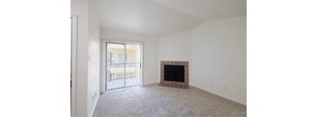 A living room with a fireplace and carpeted floor.