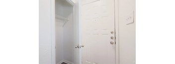 A white door with a silver handle is open.