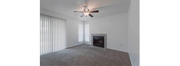 A room with a fireplace and a ceiling fan.