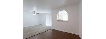 A room with a ceiling fan and a window with blinds.