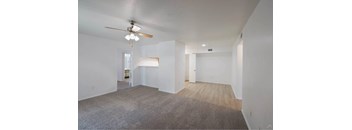 A room with a ceiling fan and carpeted floor.