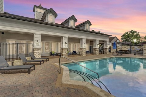 A poolside area with a building in the background.