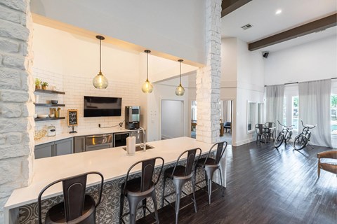 A kitchen with a white countertop and black chairs.