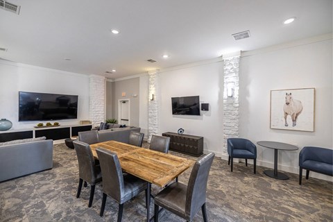 A modern dining room with a wooden table and grey chairs.