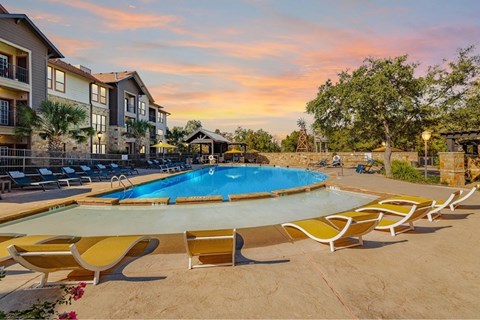A swimming pool surrounded by yellow sun loungers.